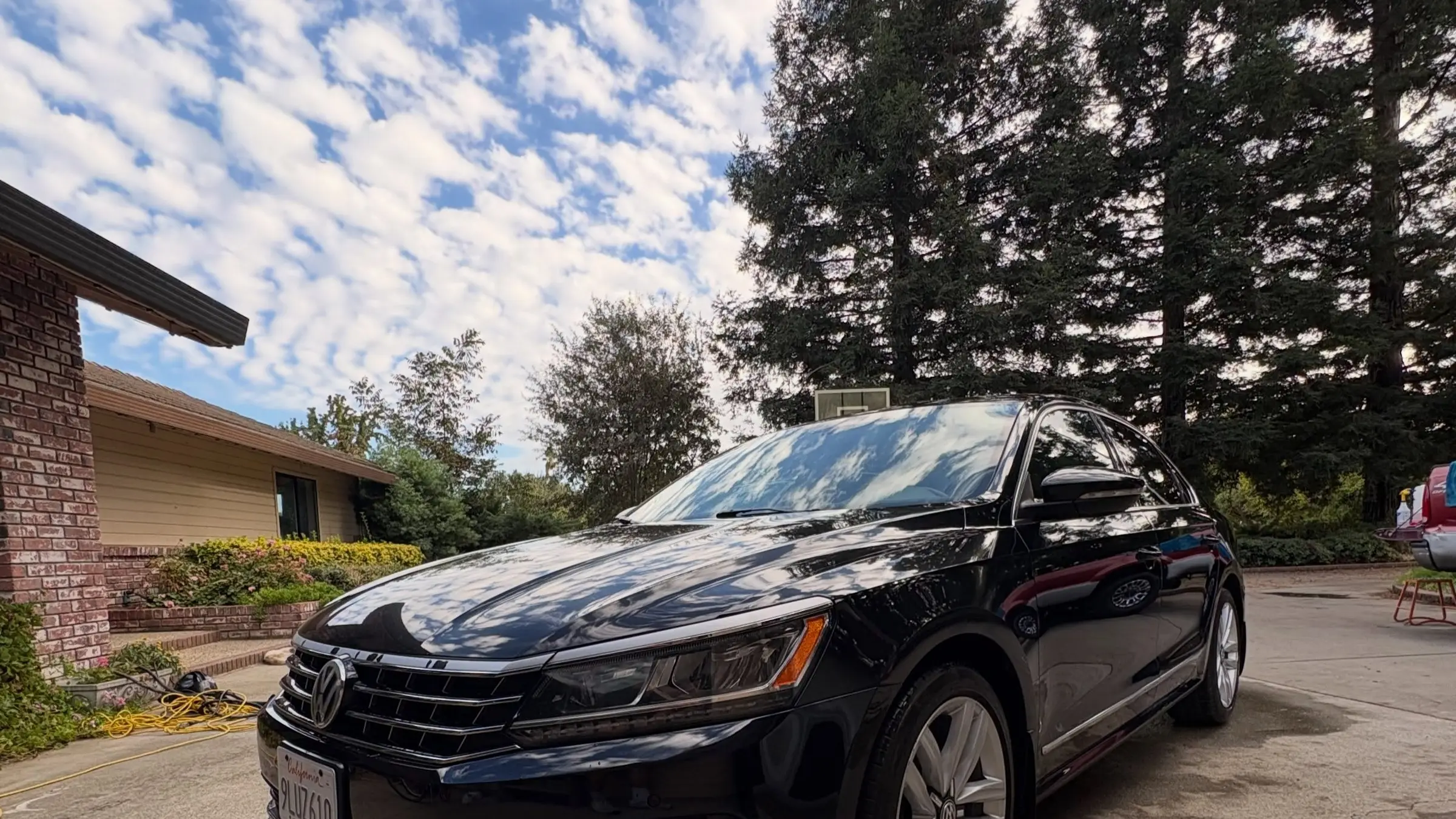 Black Volkswagen Passat detailed in a Chico driveway under a dramatic sky