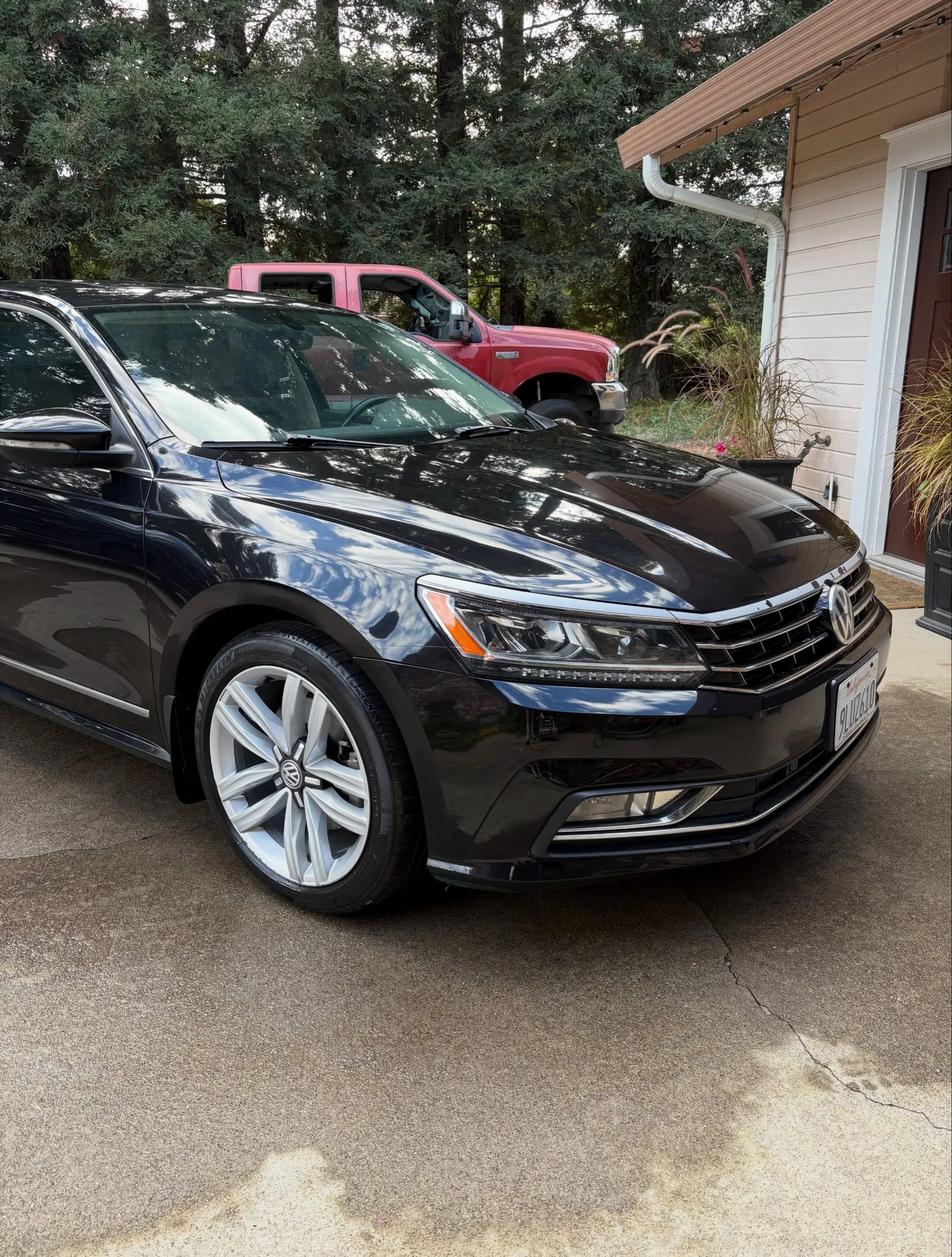 Black Volkswagen Passat, front three-quarter view, in a driveway after a detail