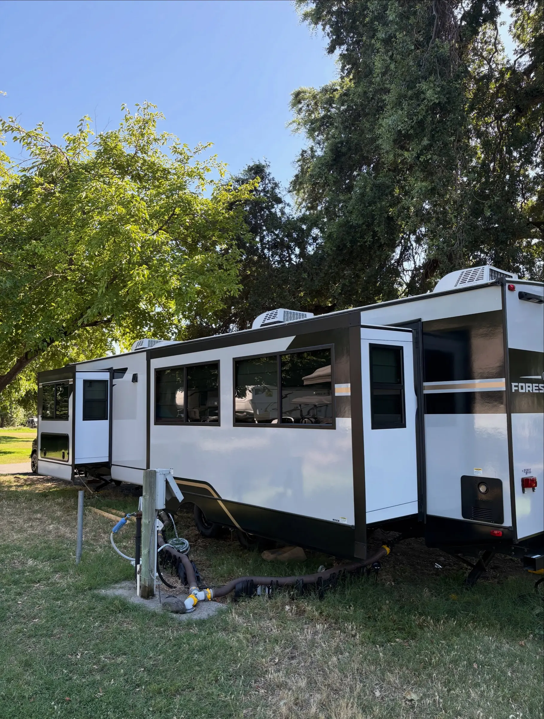 White fifth-wheel travel trailer parked on grass after an exterior detail