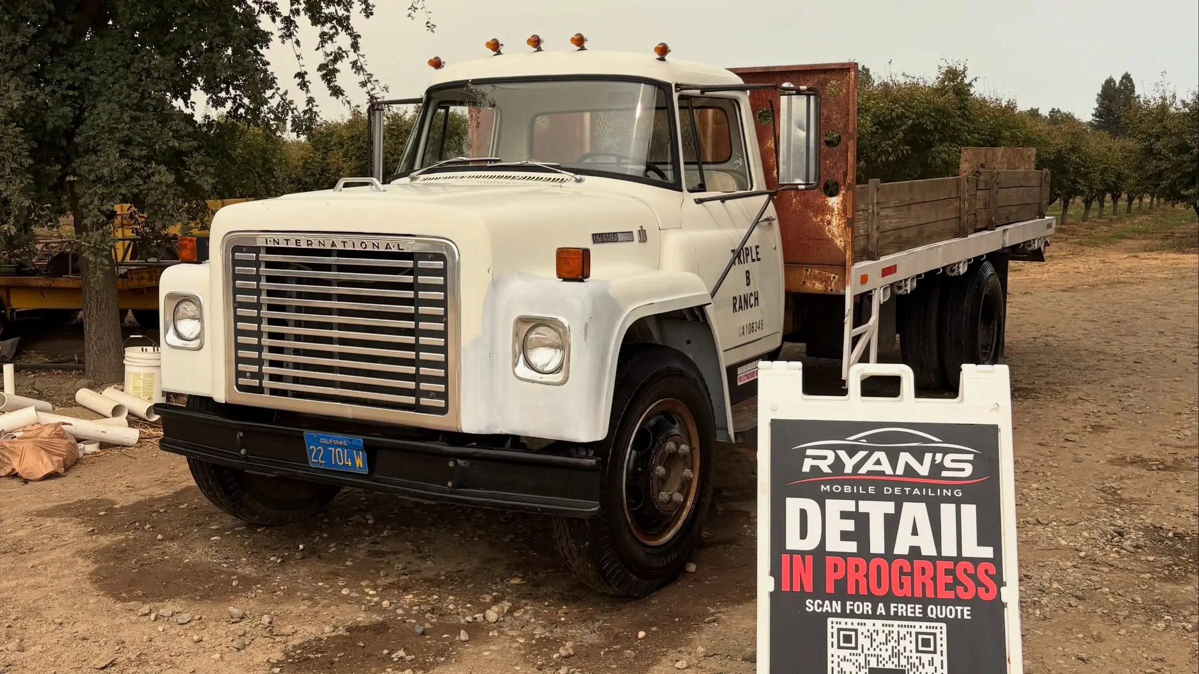 Freshly detailed pickup truck beside Ryan's Mobile Detailing sign at a ranch