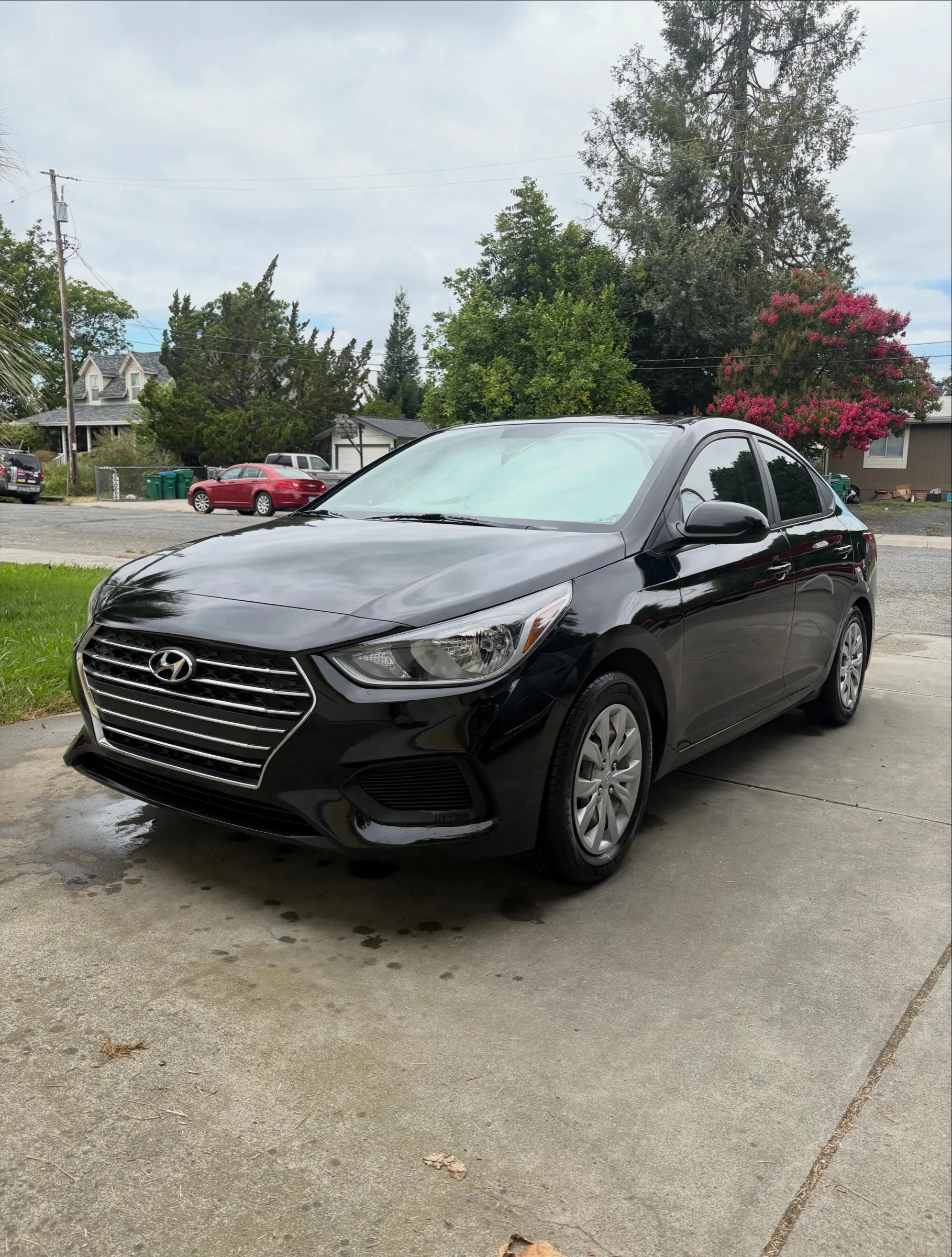 Black Hyundai Accent in a driveway after a detail