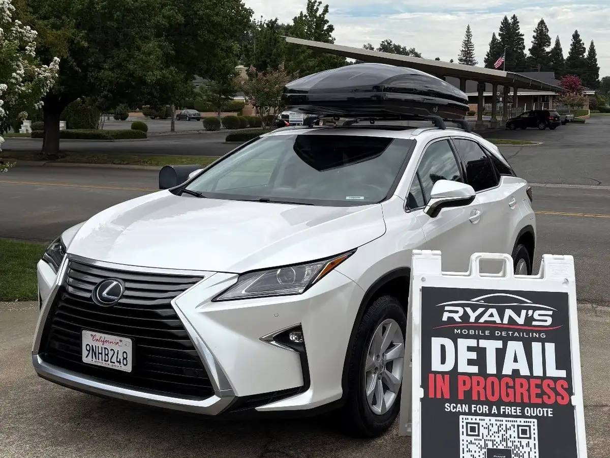 Lexus RX in a driveway beside Ryan's Detail In Progress sign