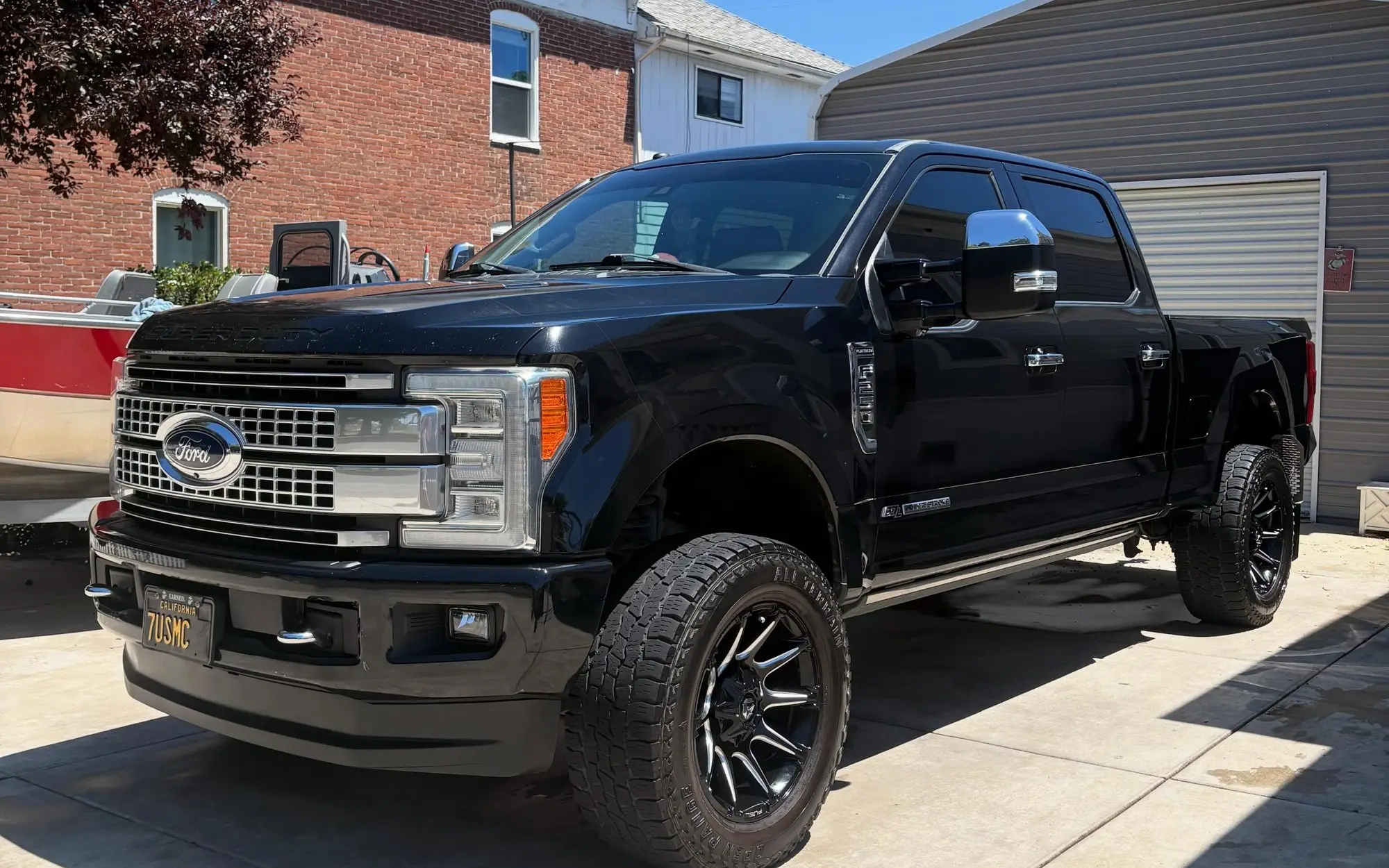 Black lifted Ford F-250 outside a brick house after a detail