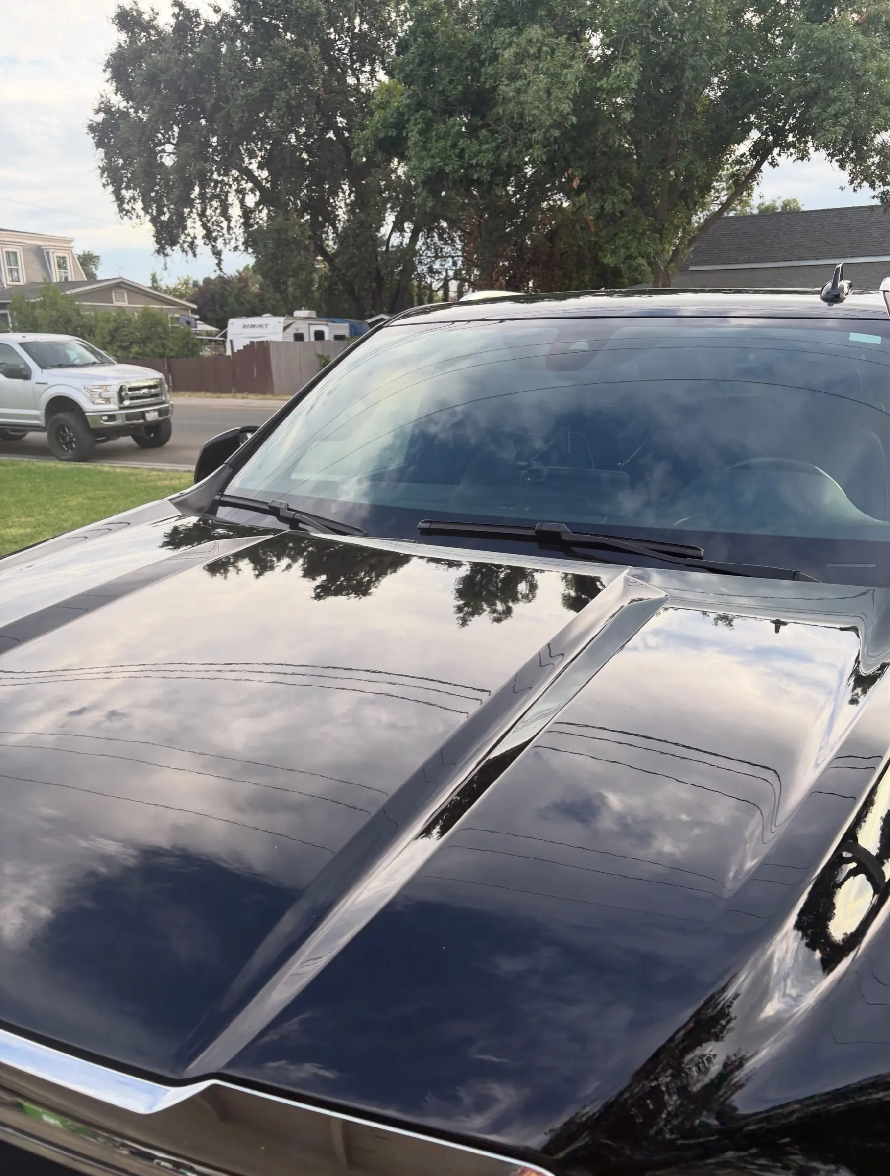 Glossy black hood of a GMC Yukon after a wash and ceramic seal