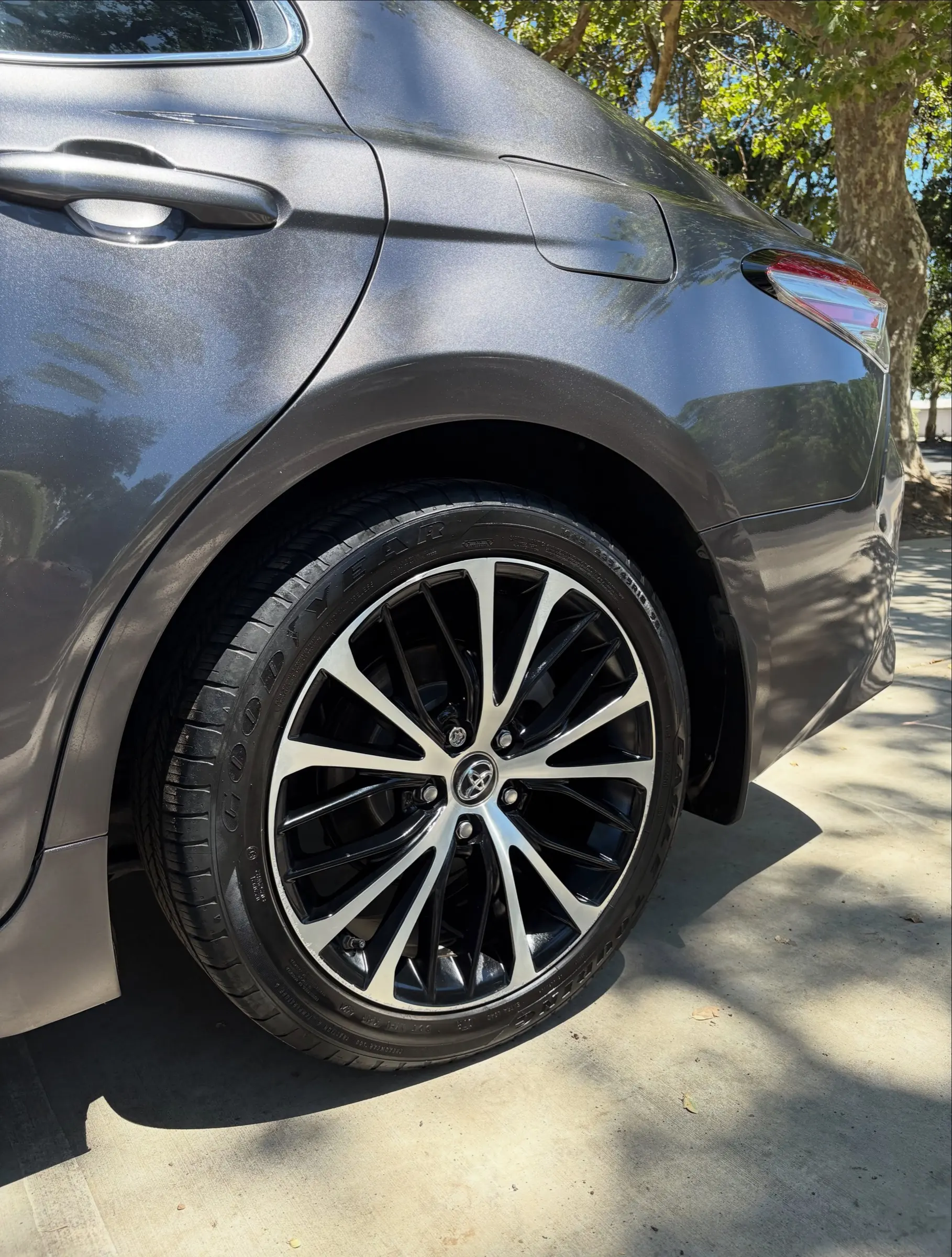 Clean alloy wheel and dressed tire on a gray Camry