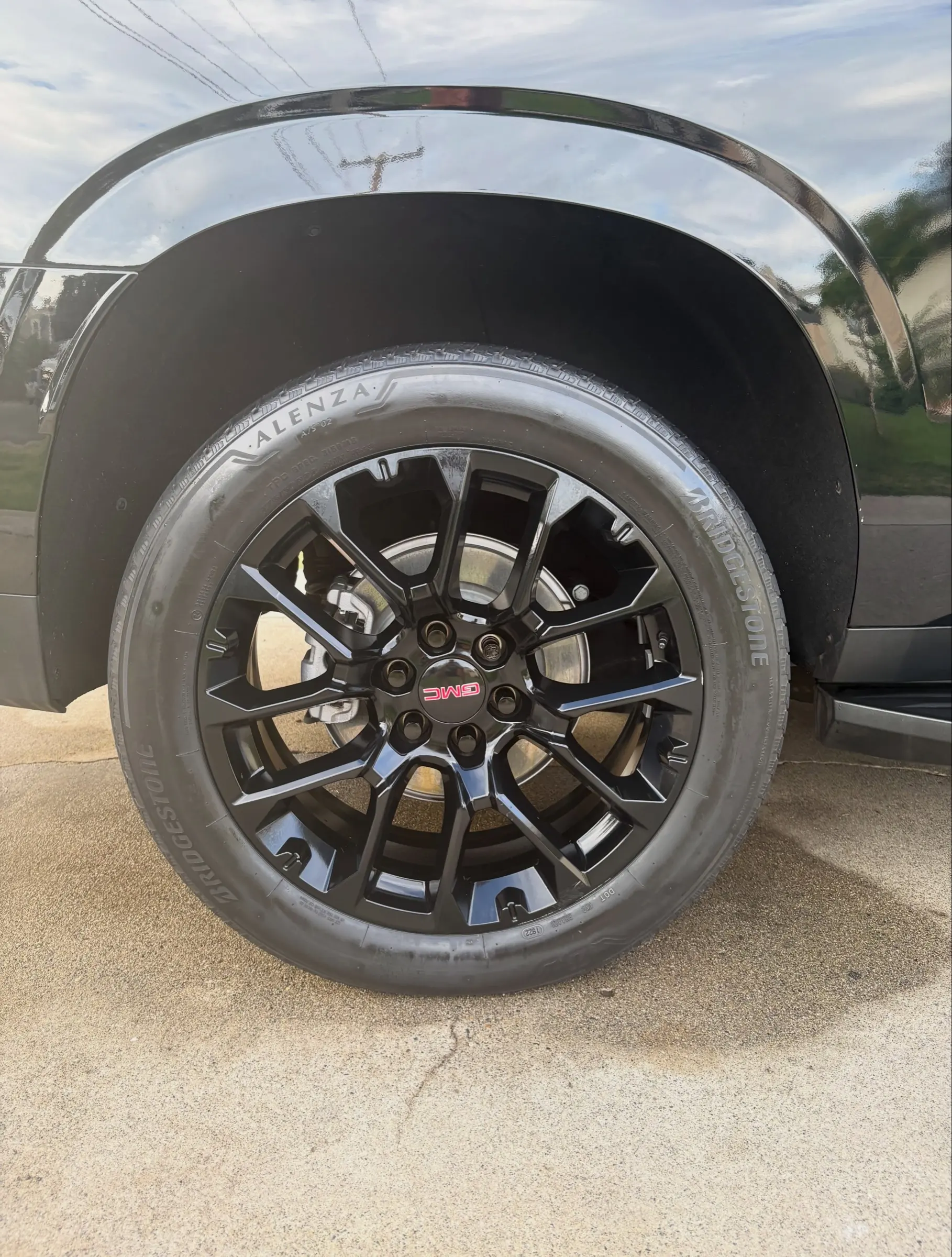 Black GMC Yukon wheel after cleaning and tire dressing
