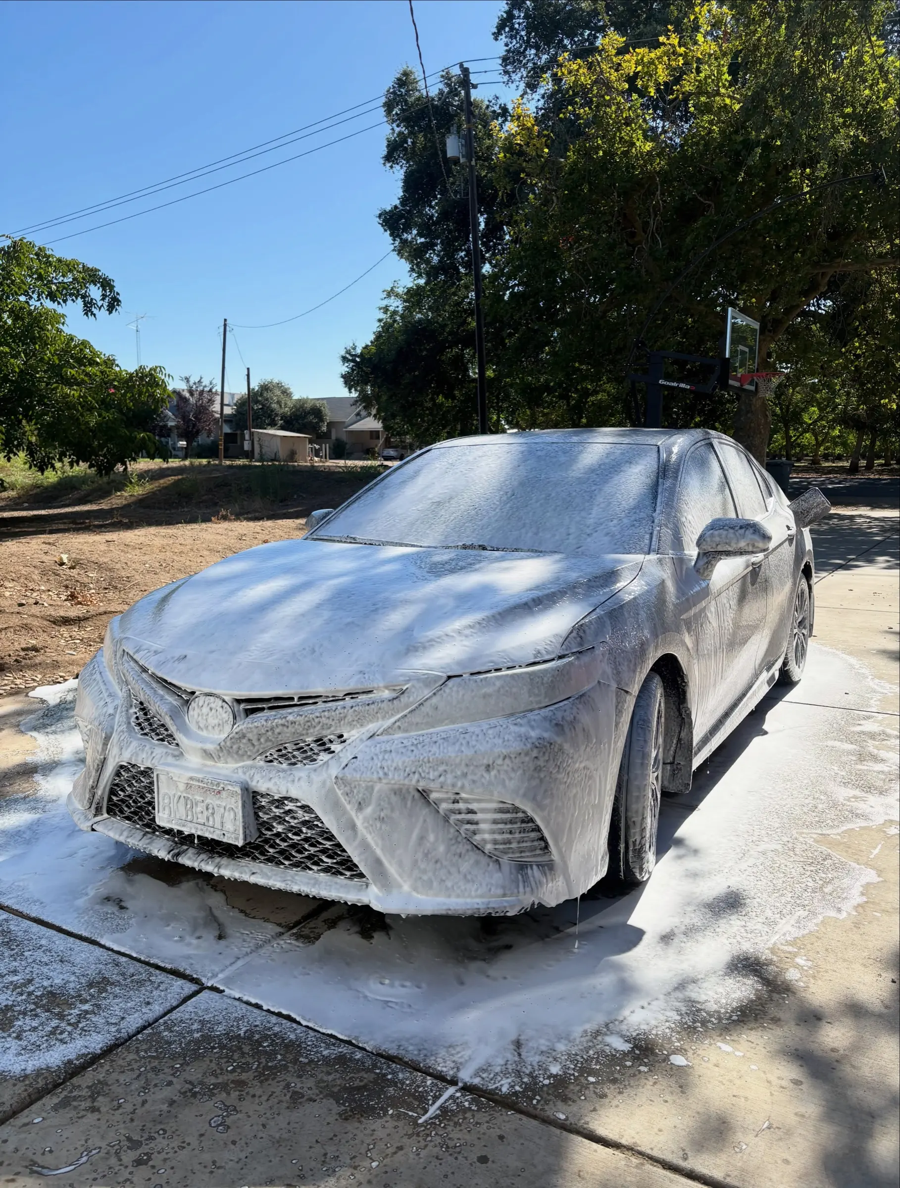 Gray Camry covered in foam during the wash